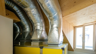 La ventilation contrôlée avec récupération de chaleur augmente l'efficacité énergétique de cet immeuble d’habitation à Lausanne, classé et qui est chauffé par le chauffage à distance.