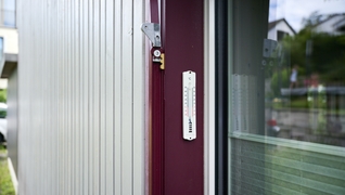 Immeuble d'habitation à Zurich Witikon : un thermomètre mesure la température devant la fenêtre.